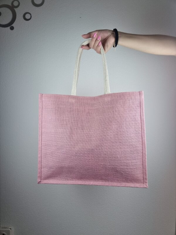 Ragazza con borsa a spalla in tela rosa, con decorazioni rosa, lavorate all'uncinetto