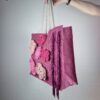 Ragazza con borsa a spalla in tela fucsia, con decorazioni a fiori rosa, lavorate all'uncinetto