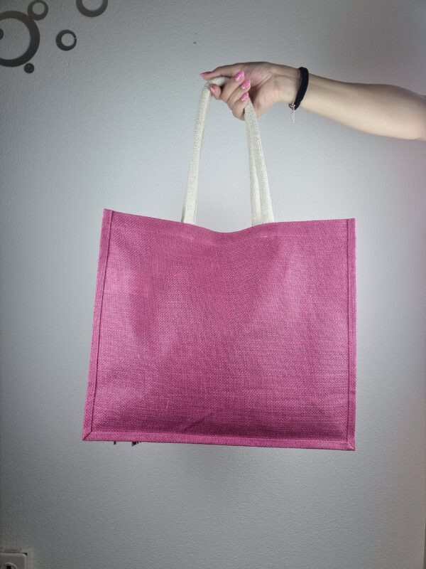 Ragazza con borsa a spalla in tela fucsia, con decorazioni a fiori rosa, lavorate all'uncinetto